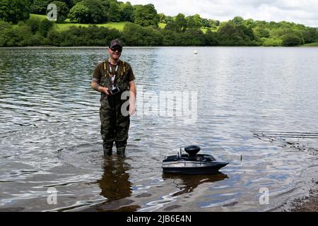 Angler in picchiaduro con barca con telecomando sul Rudyard Reservoir Staffordshire Foto Stock