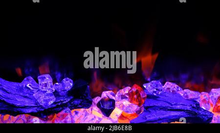 vista sul camino elettrico con fiamma artificiale scintillante, decorazioni per l'interno, fiamma arancione su cristalli viola. Foto Stock