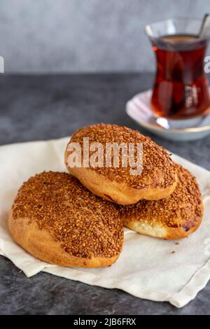 Formaggio Pogaca. Prodotto di pasticceria turca. Pogaca di sesamo su sfondo scuro. Primo piano. Nome locale kasarli pogaca Foto Stock