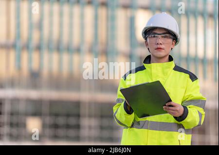 Ingegnere asiatico che lavora in loco di un grande progetto di costruzione, Thailandia persone, lavoro straordinario in cantiere Foto Stock