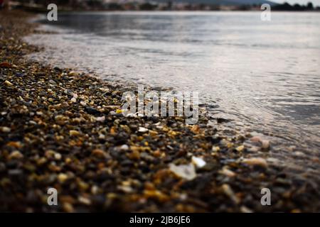 Foto ravvicinata delle onde sulle rocce colorate della spiaggia Foto Stock