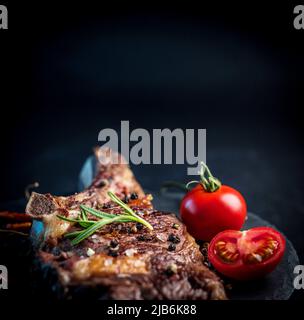 Bistecca di manzo alla griglia a osso con pomodori Foto Stock