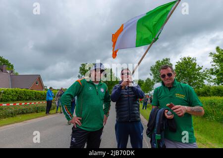 I membri della squadra irlandese che sventolano la bandiera, il campionato europeo 2022 Boßeln o la palla che spara a Süderhastedt Dithmarschen, Schleswig-Holstein, Germania settentrionale Foto Stock