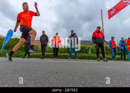 Membro della squadra olandese che lancia palla, campionato europeo 2022 Boßeln o tiro palla a Süderhastedt Dithmarschen, Schleswig-Holstein, Germania settentrionale Foto Stock