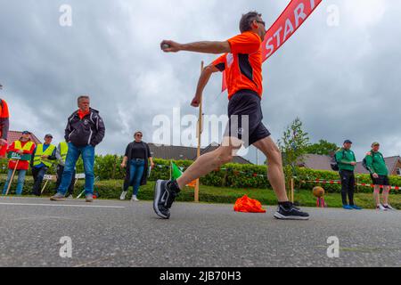 Membro della squadra olandese che lancia palla, campionato europeo 2022 Boßeln o tiro palla a Süderhastedt Dithmarschen, Schleswig-Holstein, Germania settentrionale Foto Stock