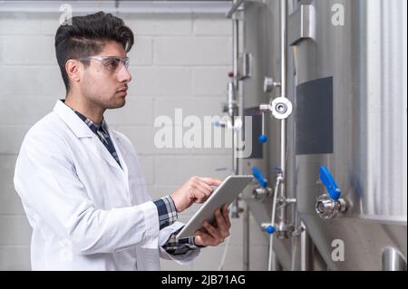 Lavorare in birrifici moderni, raccolta dati e monitoraggio della produzione. Fotografia di alta qualità. Foto Stock