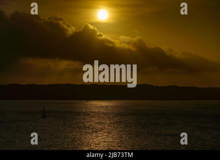 Tramonto isola sylt Mar Baltico Germania, vista romantica, barca a vela all'orizzonte molto vicino al sole Foto Stock