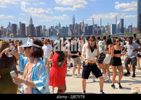 Persone che ballano al Hot Honey Sunday, festa all'aperto di ballo al Greenpoint Terminal Market con East River e lo skyline di Manhattan sullo sfondo.Greenpoint.Brooklyn.New York City.USA Foto Stock