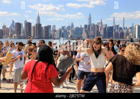 Persone che ballano al Hot Honey Sunday, festa all'aperto di ballo al Greenpoint Terminal Market con East River e lo skyline di Manhattan sullo sfondo.Greenpoint.Brooklyn.New York City.USA Foto Stock