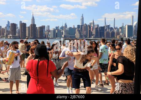 Persone che ballano al Hot Honey Sunday, festa all'aperto di ballo al Greenpoint Terminal Market con East River e lo skyline di Manhattan sullo sfondo.Greenpoint.Brooklyn.New York City.USA Foto Stock