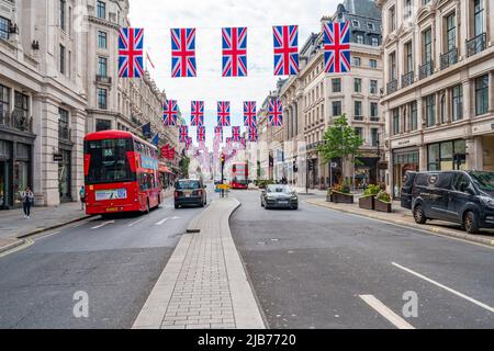 LONDRA, UK - 03 GIUGNO 2022: File di bandiere dell'Unione appendono sopra Regent Street per celebrare le celebrazioni del Giubileo del platino della regina. Foto Stock