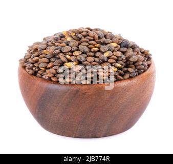 Lenticchie francesi in ciotola di legno, isolate su sfondo bianco. Asciutto puy lentil granisce mucchio Foto Stock