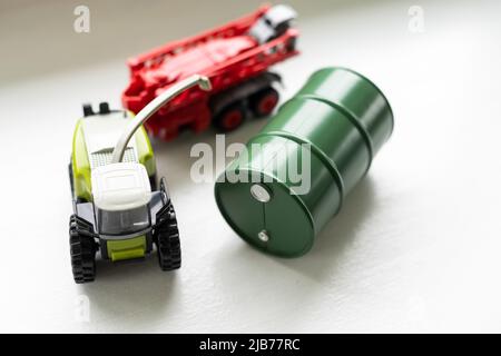 trattore giocattolo con il cilindro dell'olio giocattolo su sfondo bianco. Foto Stock