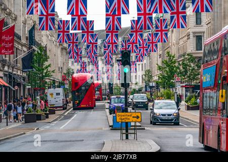 LONDRA, UK - 03 GIUGNO 2022: File di bandiere dell'Unione appendono sopra Regent Street per celebrare le celebrazioni del Giubileo del platino della regina. Foto Stock