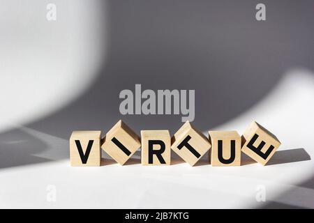 Parola VIRTÙ su cubi di legno e bello sfondo bianco. Foto Stock