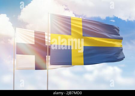 Cielo azzurro soleggiato e bandiere di svezia e finlandia Foto Stock