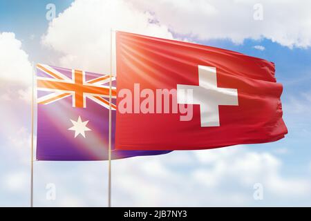 Cielo azzurro soleggiato e bandiere di svizzera e australia Foto Stock