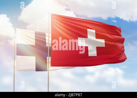 Cielo azzurro soleggiato e bandiere di svizzera e finlandia Foto Stock