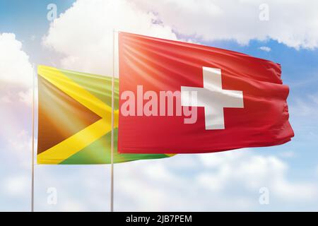 Cielo azzurro soleggiato e bandiere della svizzera e della giamaica Foto Stock