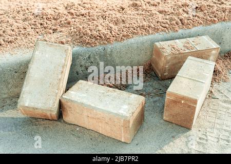 le lastre di pavimentazione sono preparate per la posa in prossimità del marciapiede in cantiere Foto Stock