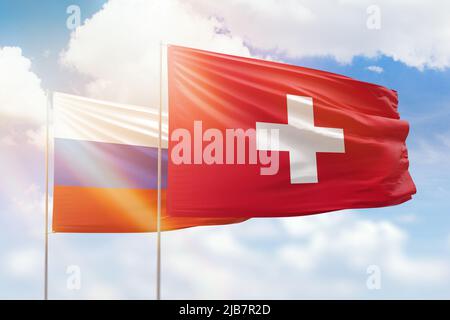 Cielo azzurro soleggiato e bandiere di svizzera e russia Foto Stock