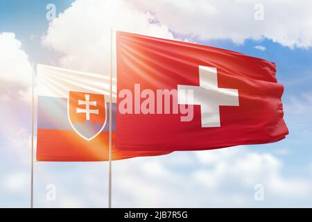 Cielo azzurro soleggiato e bandiere di svizzera e slovacchia Foto Stock