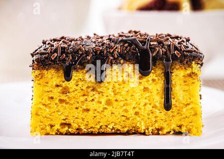 Fetta di torta di carote con crema di cioccolato e spolverini, tipico dei festival brasiliani di giugno, torta fatta in casa Foto Stock