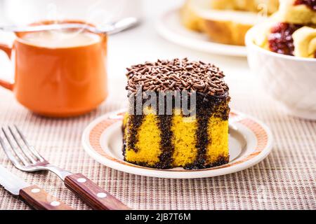 torta di carote con spolverini di cioccolato, glassa cremosa che gocciola la torta, servita con latte Foto Stock