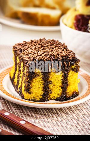 Torta di carota con spolverate di cioccolato, glassa cremosa che gocciola sulla torta, dolce tipico brasiliano alle feste di giugno Foto Stock