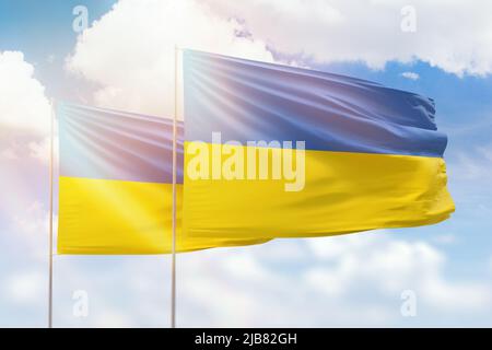 Cielo azzurro soleggiato e bandiere di ucraina e ucraina Foto Stock