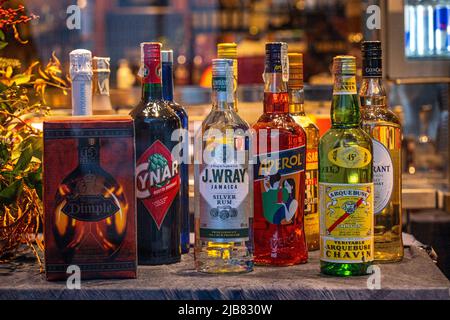 Venezia, Italia - 18.02.2022: Bottiglie di liquori globali assortiti, tra cui whiskey, aperol, rum e chavin Arquebuse Foto Stock