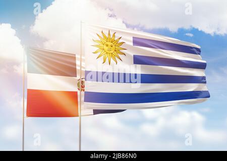 Cielo azzurro soleggiato e bandiere dell'uruguay e della repubblica dominicana Foto Stock