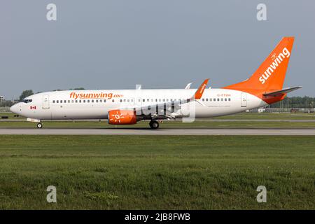 Un Boeing 737-800 Sunwing Airlines è appena arrivato all'aeroporto internazionale Pierre Elliott Trudeau di Montreal. Sunwing Airlines è una compagnia aerea a basso costo canadese con sede a Toronto. Sunwing Airlines offre servizi di linea e charter da Canada e Stati Uniti a destinazioni all'interno di Stati Uniti, Messico, Caraibi, America Centrale e Sud America nei mesi invernali. Foto Stock