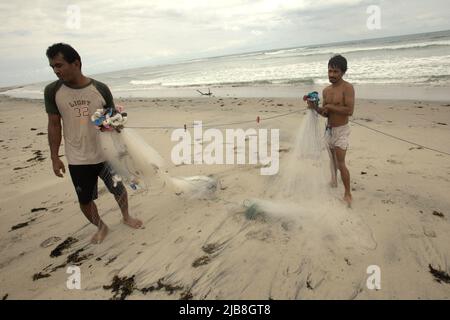 Pescatori che organizzano reti da pesca sulla spiaggia di Kalala a Wula, Wula Waijelu, Sumba orientale, Nusa Tenggara orientale, Indonesia. Foto Stock