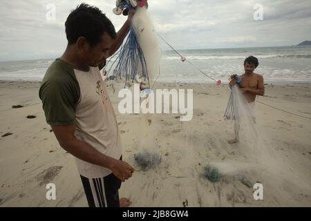 Pescatori che organizzano reti da pesca sulla spiaggia di Kalala a Wula, Wula Waijelu, Sumba orientale, Nusa Tenggara orientale, Indonesia. Foto Stock