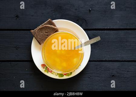 zuppa di piselli di verdure e una fetta di pane nero su un tavolo di legno nero in cucina, zuppa senza carne Foto Stock