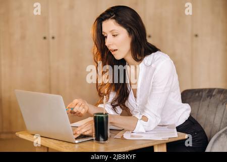 La ragazza è seduta a una scrivania in ufficio e di lavoro. Foto Stock