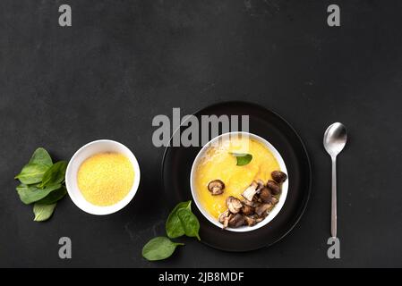 Shot di polenta di cottura. La polenta è un piatto tradizionale dell'Italia settentrionale a base di farina di mais grossolana. Un classico contorno di polenta di porridge di mais con Foto Stock