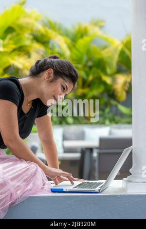 Ritratto di giovane donna latina usando il computer portatile all'aperto - foto di scorta Foto Stock
