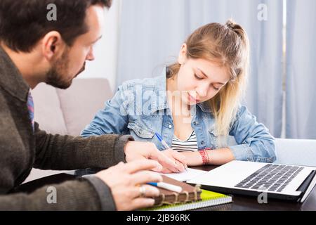 Il tutor aiuta l'adolescente a prepararsi Foto Stock