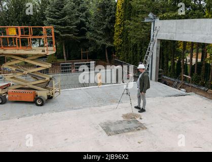 Opere geodetiche. Ingegnere Surveyor che utilizza attrezzature geodetiche in cantiere. Attrezzatura professionale per building. Lavoro come un topografo. Ottico Foto Stock