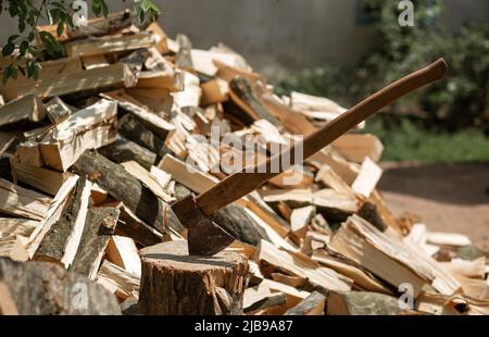 AX sullo sfondo di legna da ardere tagliata per accendere la stufa Foto Stock