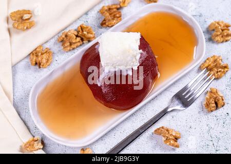 Dolce di mele cotogne. Prelibatezze della cucina tradizionale turca. Dolce di mele cotogne con panna su sfondo di pietra. Primo piano. Nome locale ayva tatlisi Foto Stock