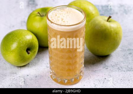 Succo di mela. Succo appena spremuto. Succo di mela appena spremuto in vetro su sfondo di pietra. Primo piano Foto Stock