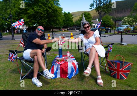 Ballater, Scozia, Regno Unito. 4 giugno 2022. La celebrazione del Giubileo del platino della Regina si celebra nel villaggio di Ballater, vicino a Balmoral, sul Royal Deeside, nell'Aberdeenshire. PIC; Julie e George dall'Hampshire godono di bevande sul prato nel verde del villaggio a Ballater. George era una guardia reale nella vicina Balmoral 40 anni fa. Iain Masterton/Alamy Live News Foto Stock
