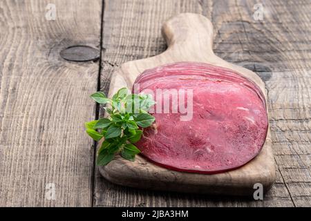 Fetta di carne di manzo secca a scatti su sfondo di legno Foto Stock