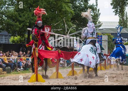 Pfingst-Spektakulum a Muelheim an der Ruhr, Germania. Cavalieri a cavallo. Evento con un torneo medievale di cavalieri con accampamento e mercato dell'artigianato a Müga-Park vicino al castello Schloss Broich. Foto Stock