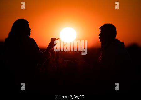 Berlino, Germania. 04th giugno 2022. Due donne stanno parlando sulla montagna del drago di fronte al sole del tramonto. Credit: Christoph Soeder/dpa/Alamy Live News Foto Stock