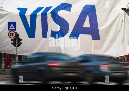 Bucarest, Romania - 03 gennaio 2022: Una grande pubblicità VISA (fuoco selettivo - intenzionaly motion blur) su un enorme banner è stato sollevato su un bui Foto Stock