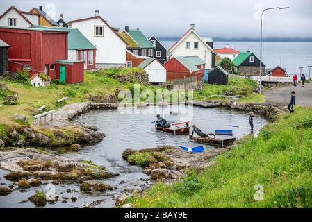 Bambini che giocano su un laghetto artificiale nel villaggio di Gjogv, Isola Eysturoy, Arcipelago di Faroe Foto Stock